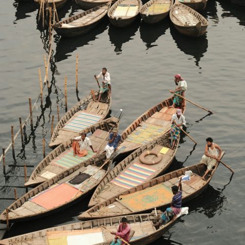 নদীতে সারি সারি কাঠের নৌকা