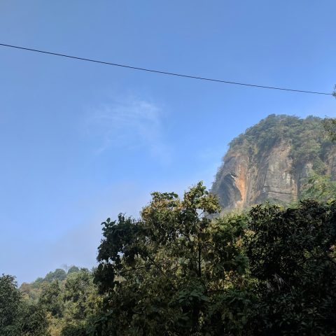 নীল আকাশের নিচে বনাচ্ছাদিত পাহাড়